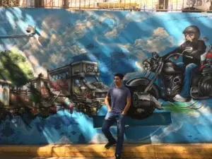 Un élève pose devant une fresque murale