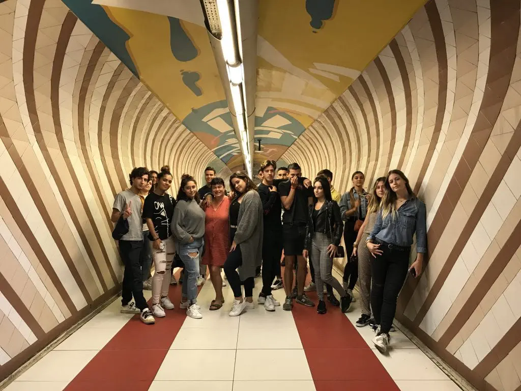 Groupe de jeunes posant dans un couloir coloré du métro