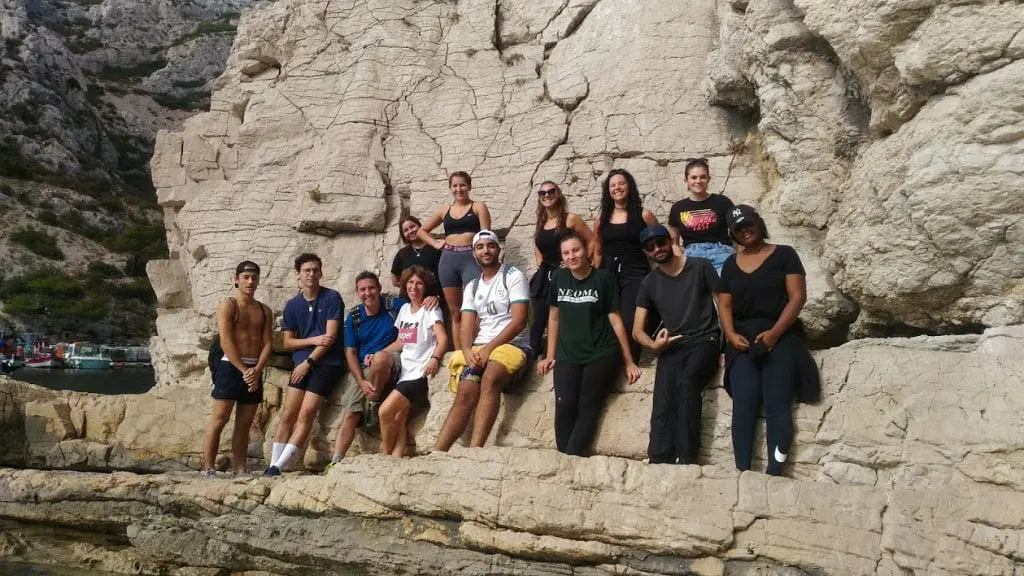 Un groupe de jeunes appuyé sur une roche du massif des calanques